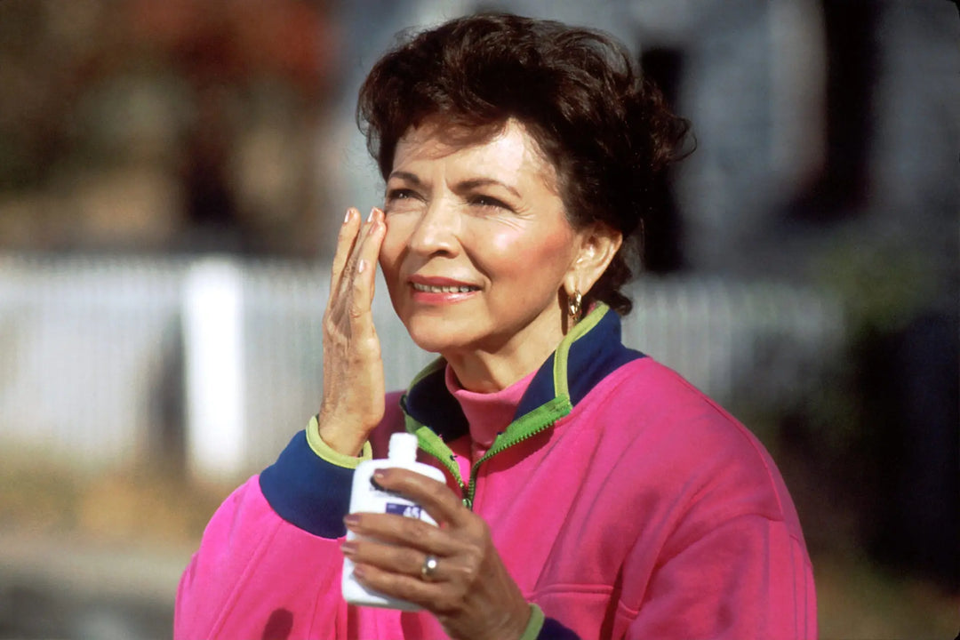 Person applying sunscreen to protect skin and preserve youth.